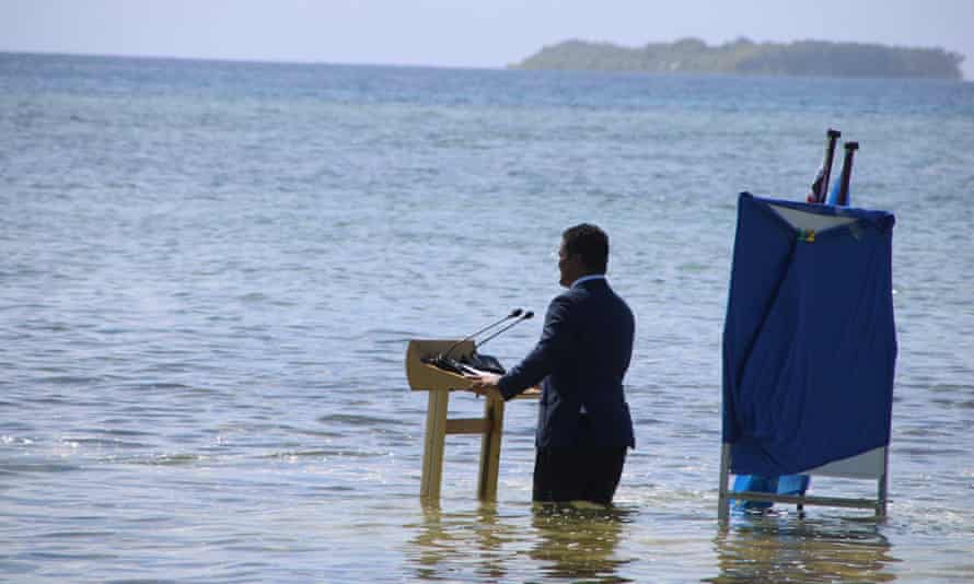 Tuvalu’s foreign affairs Simon Kofe speaks while standing knee-deep in the ocean in Funafuti, Tuvalu