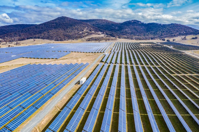 Rows of solar panels with mountain in background