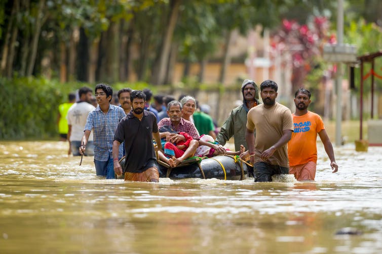 People walk through flooded street