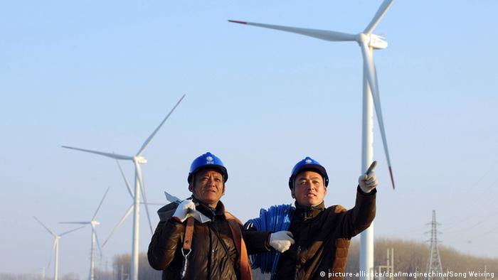 Workers in front of a wind farm in China