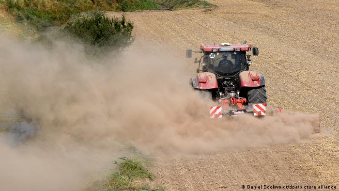 Dust billowing from the back of a tractor 