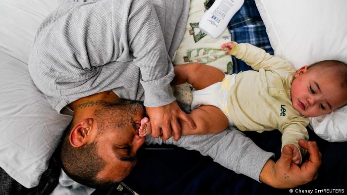 Anthony Vasquez, 42, kisses the foot of his four-month-old son Michael at the emergency shelter in Windigo, Kentucky.