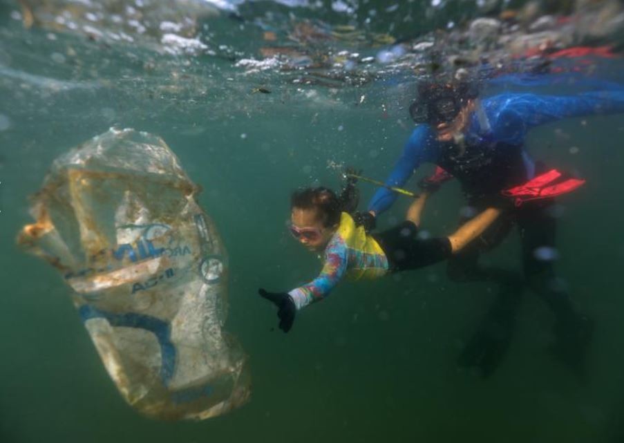 4-year-old Nina, accompanied by her marine biologist father, removes plastic waste at the Praia Vermelha beach in Rio in July. 