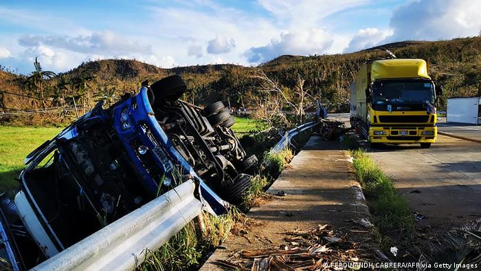 Trucks overturned at the height of super Typhoon Rai are left idle along a highway in Surigao city