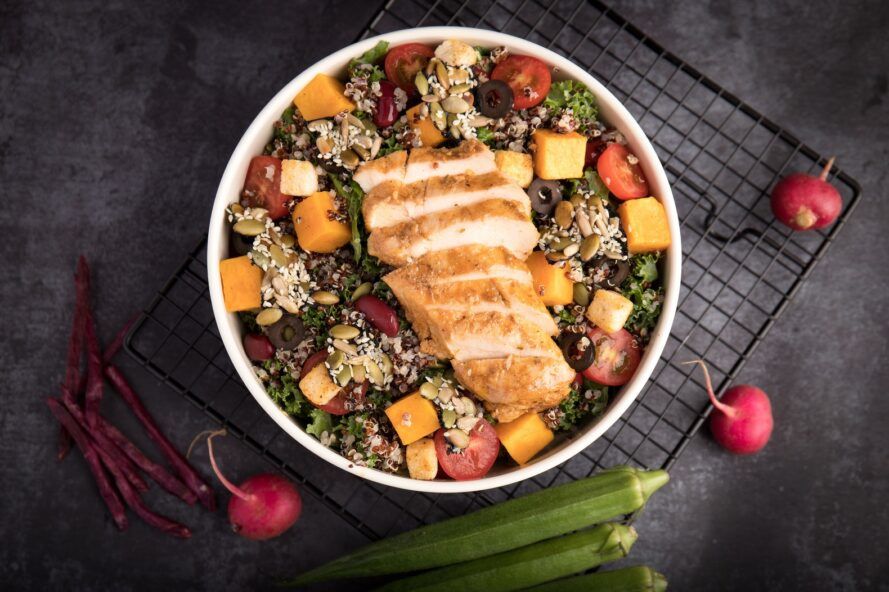 A bowl filled with chicken and grains