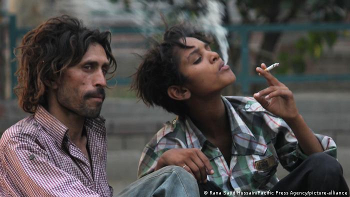 Two people in Pakistan smoking cigarettes