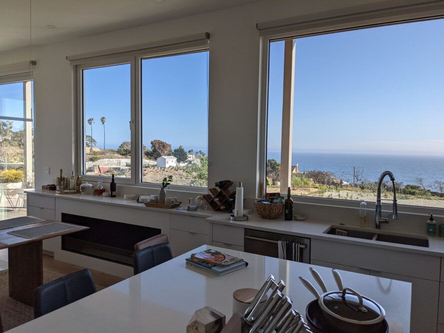 Large windows in a kitchen looking out on the coast.