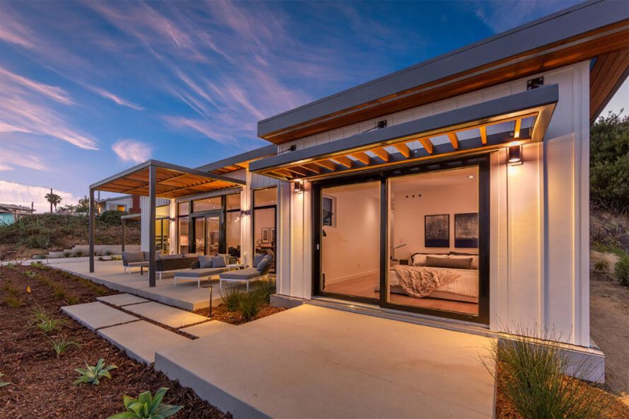 A home with open decks lit up at dusk.