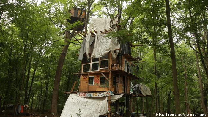 A treehouse with windows and tarps in the forest