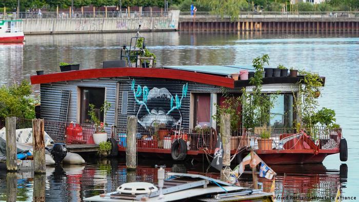 A colorful house boat with plants on its deck