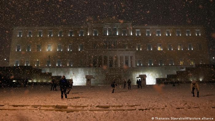 People enjoy the snow in front of the Greek Parliament during snowstorm in Athens, Greece