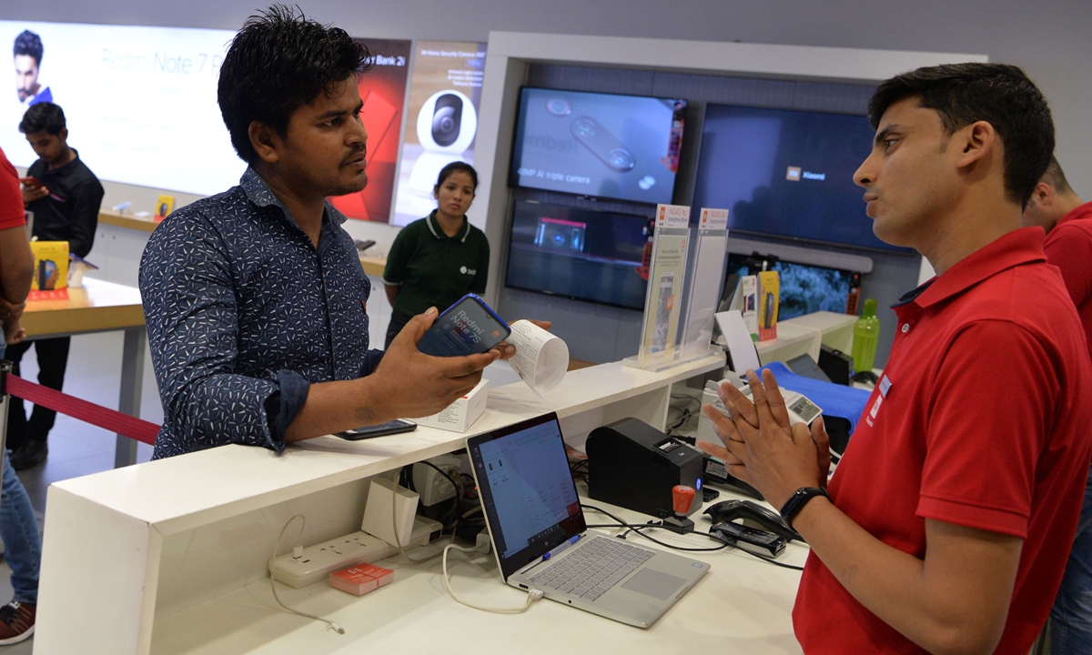 In this photo taken on August 20, 2019, a salesman speaks with a customer after he purchased a new smartphone made by Xiaomi at a Mi store in Gurgaon, India. Photo: VCG