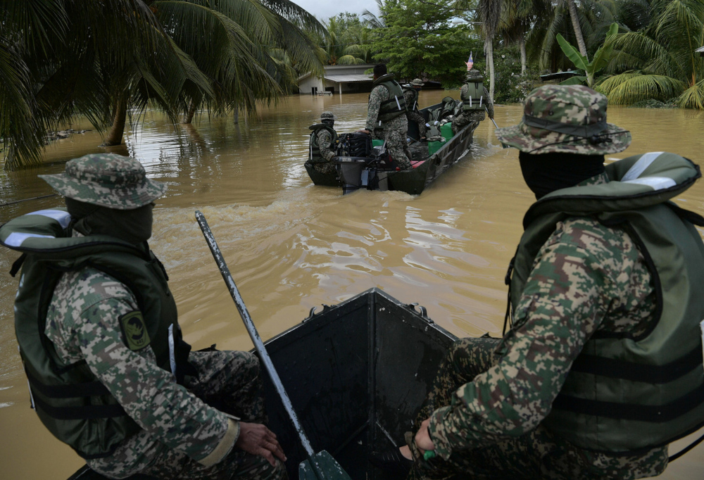Malaysian Armed Forces personnel use boats to ferry food and frontliners from Kampung Spang Loi to Kampung Padang Kiambang in Segamat, Johor, January 4, 2022.  Bernama pic