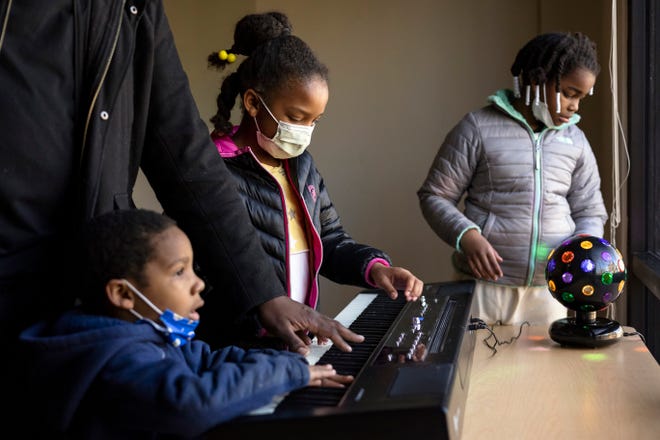 Solomon Smothers, Lora Smothers' husband, plays the piano with their children, Ruby, 6, and Jericho, 2, during the Joy Village Schools preview day for potential students and their families on Saturday, Feb. 5, 2022, in Athens.