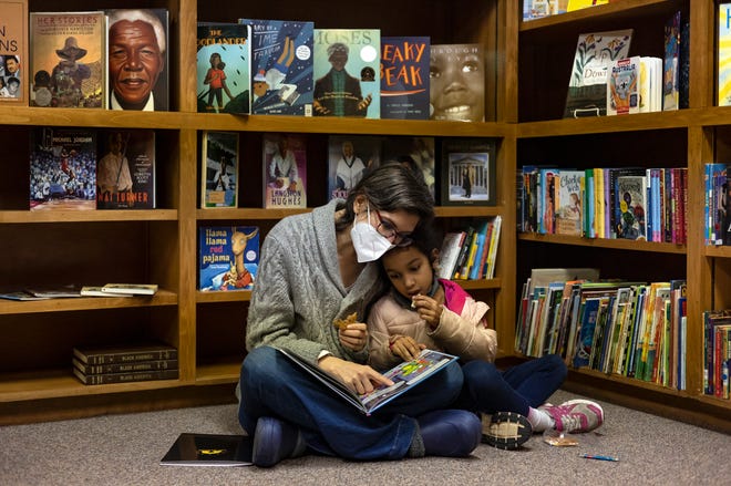 Bonnie Osei-Frimpong reads to her daughter, Graham, 7, in the Joy Village Schools library during a preview day for potential students and their families on Saturday, Feb. 5, 2022 in Athens.