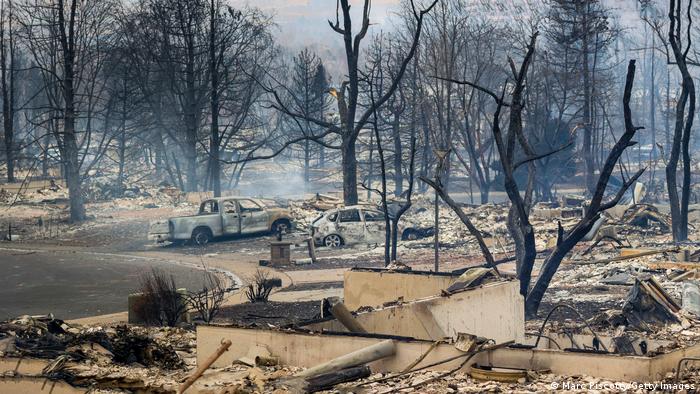 Burned out cars, charred trees and decimated houses in the aftermath of a fire