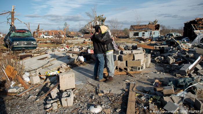Cousins embrace admist the wreckage left by tornado in Dawson Springs, Kentucky, USA