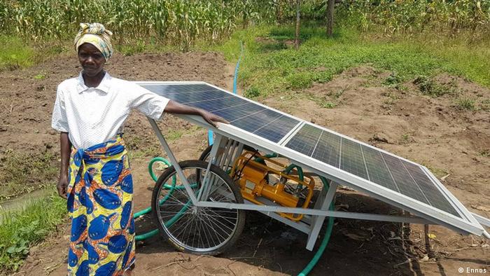 Mobile solar water pump in Rwanda, farmer stands in front