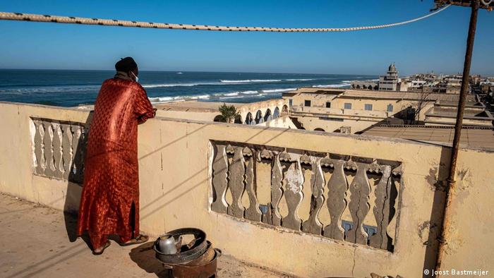 A man looking over the rooftops of Guet Ndar, a neighborhood on Langue de Barbarie 