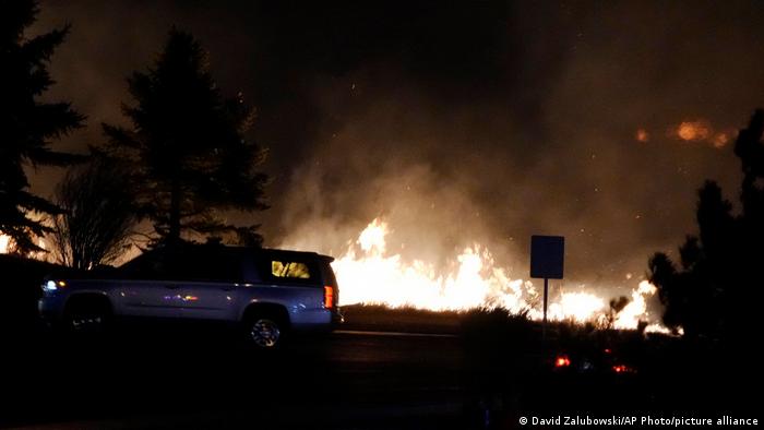Flames explode as wildfires burned near a small shopping center