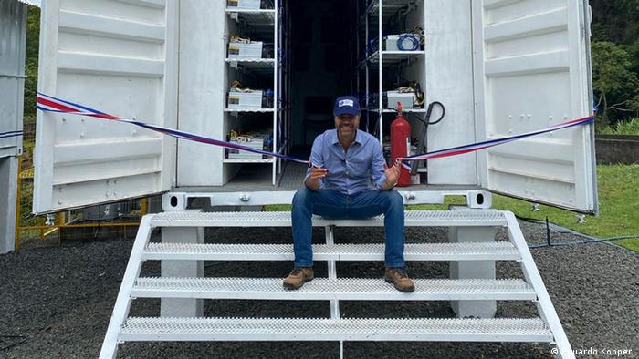 Eduardo Kopper sits in front of a container at his Poas I crypto-mining project in Costa Rica