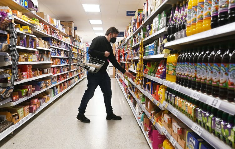 Man reaches for item in supermarket