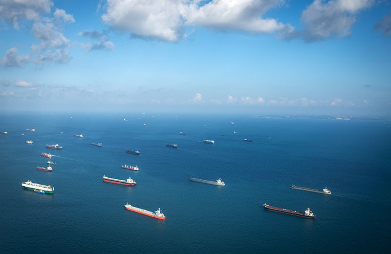 Cargo ships like these wait off the Southern California coast, affecting the local environment. (Image Source: iStock.)
