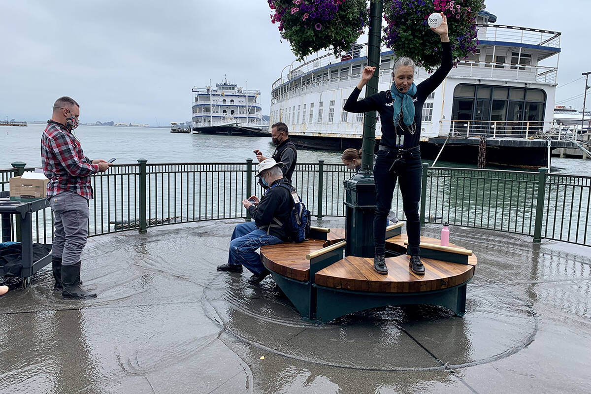Lori Lambertson, an educator with the Exploratorium teaching a group about King Tides as the water flows onto Pier 14 on Saturday, Dec. 4, 2021. (Jessica Wolfrom/The Examiner)