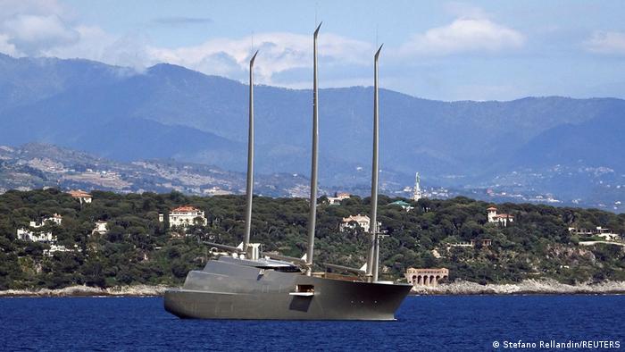 A large yacht in a bay backgrounded by mountains 