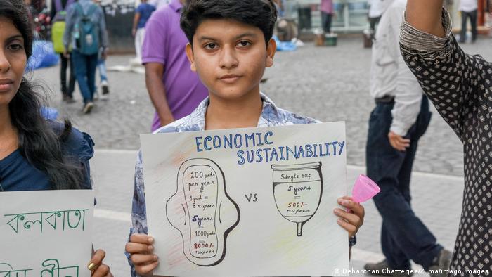 A girl holding up a sign promoting sustainable menstrual products 