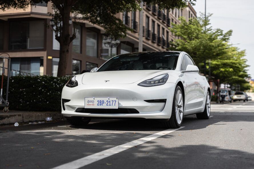 A white Tesla electrical vehicle car on a city street