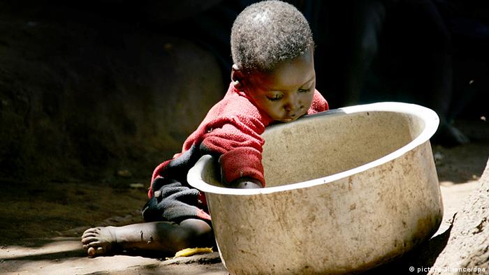 A small child with a hand in a large bowl