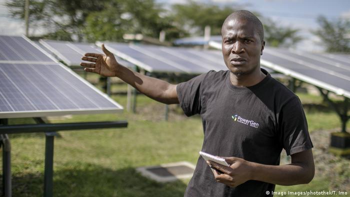George Ndubi stands in front of the solar panels