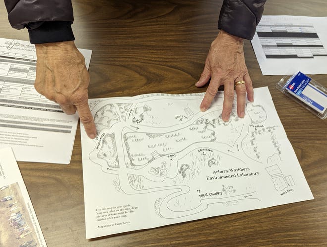 Donna Summers points out the woodlands area on the map of the Auburn-Washburn USD 437 Environmental Education Lab.