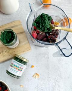 A blender and a spoon of fresh spirulina to make a smoothie