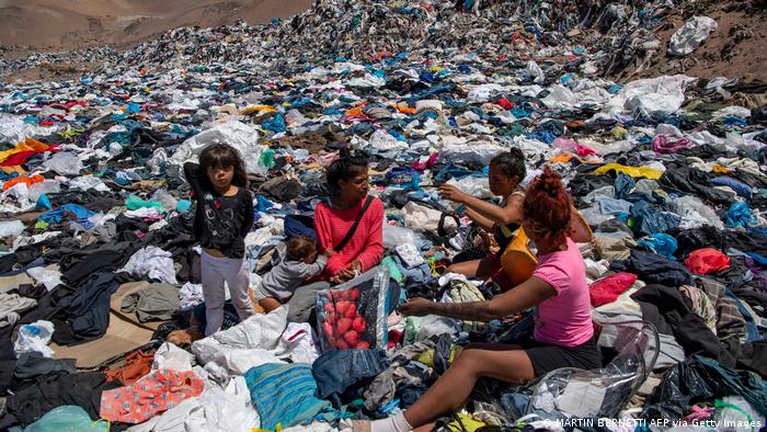 People rummage through a garbage dumps to find clothes 