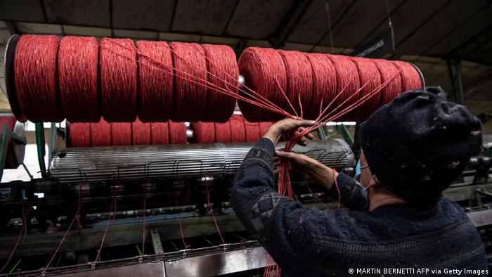 A woman working at a yarn machine