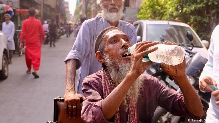 Man drinking water during a heat wave in India