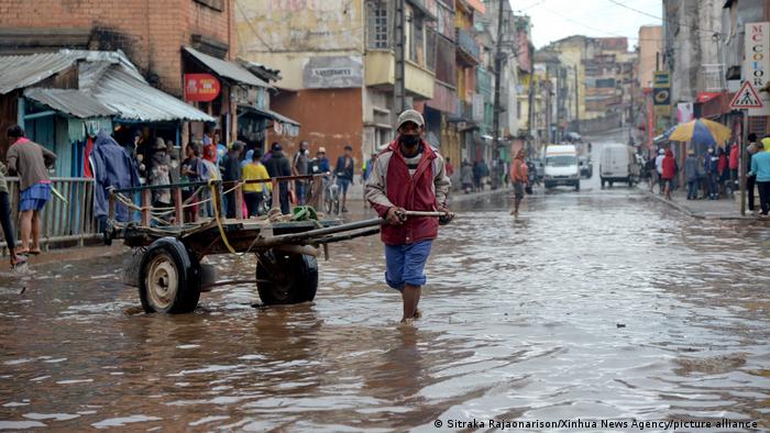 A man pulling a cart through floodwaters